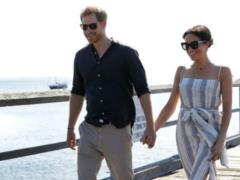 Pregnant Megan in a sundress with a high slit and sandals for the hand with her husband visited the island of Fraser