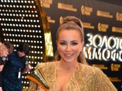 Ani Lorak in a gold mini rain dress and platform sandals showed a figure