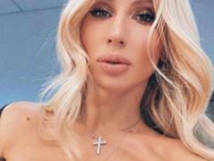 Long-legged Svetlana Loboda in a powdery mini dress posed near the Christmas tree with her daughter