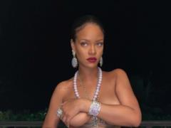 Rihanna in shorts covered her naked lush breasts with her hand