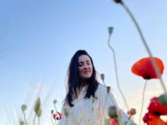 Solomiya Vitvitskaya in a light blouse charmed with a gentle photoset in a poppy field