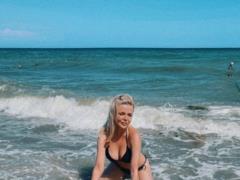 Busty Alina Grosu in bikini poses erotically in the waves of the sea