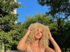 Lesya Nikityuk in a bikini posed playfully on a deck chair