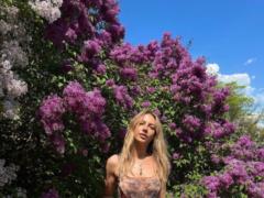 Lesya Nikityuk in a short top arranged a photo shoot among the blooming lilacs